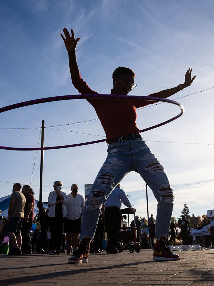 A silhouette of a person with a hula hoop against a blue sky in Lakewood, WA.