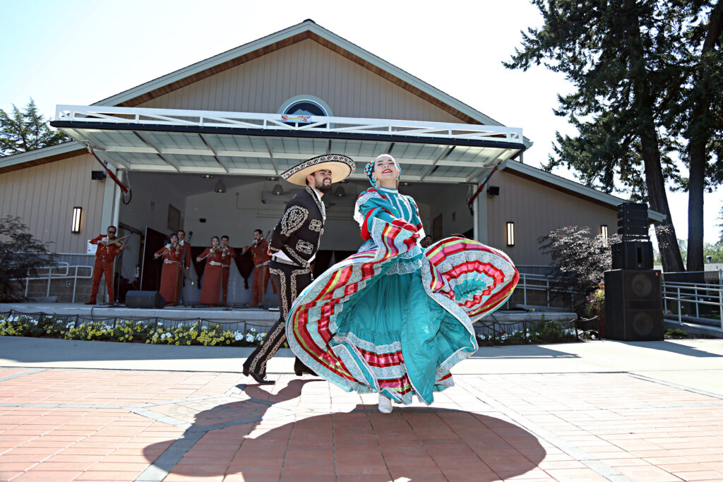 Two people dance together in the sun in traditional Mexican attire at the Fiesta de la Familia in Lakewood, WA in 2023.