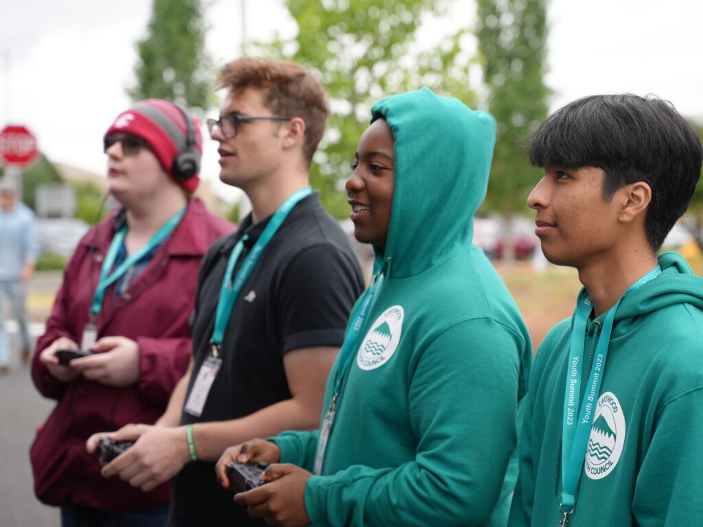 Four Lakewood teenagers play video games at a video game truck at the Youth Summit.